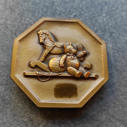 Médaille par P.Turin représentant un jeune enfant et ses jouets. En bronze. 54.7 mm 137.7 gr